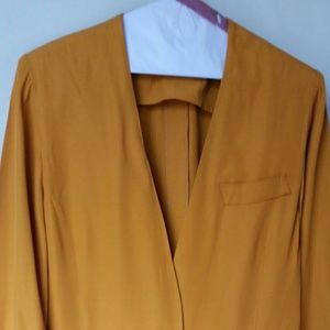 Dark mustard colored blazer with black cuffs